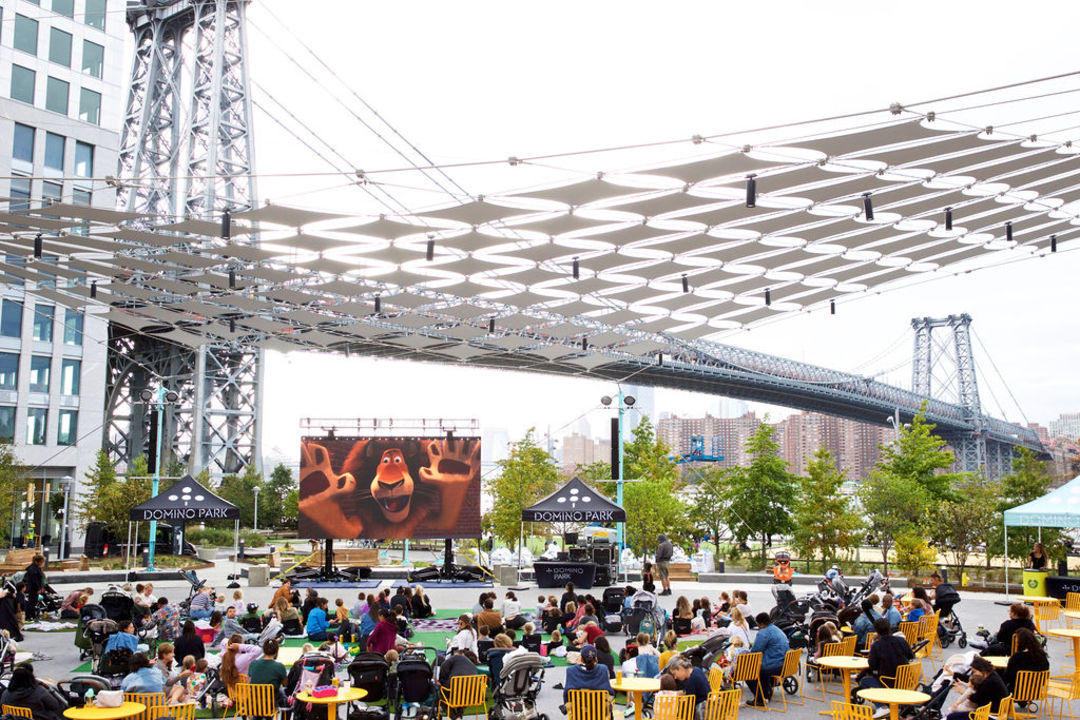 Free Things To Do in New York This Week, Free Things To Do in New York This Week, things to do in new york, things to do in nyc, free things nyc, Crowds watching outdoor movies at Domino Square, with blankets, snacks, and city skyline in the background